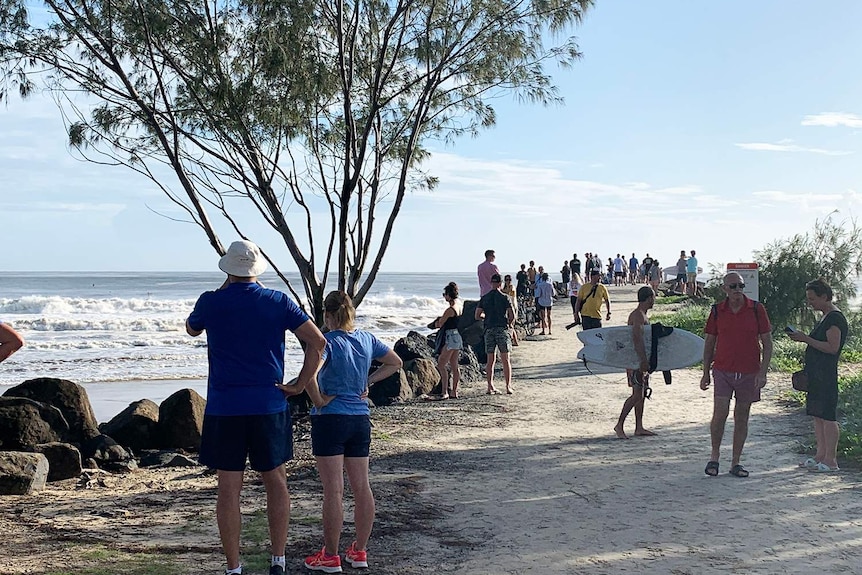 Crowd gathers to watch surf conditions at Kirra.