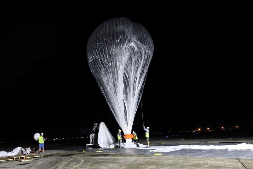A large transperant balloon prepares for launch.  