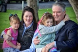 Mathias Cormann holds his daughter alongside his wife and their other child.