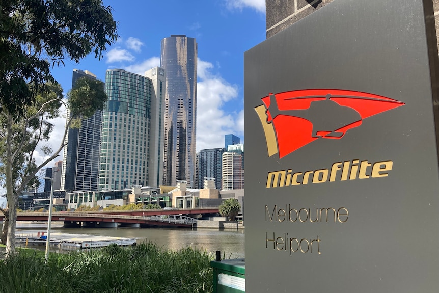 A sign bearing the company name Microflite with the city of Melbourne in the background.