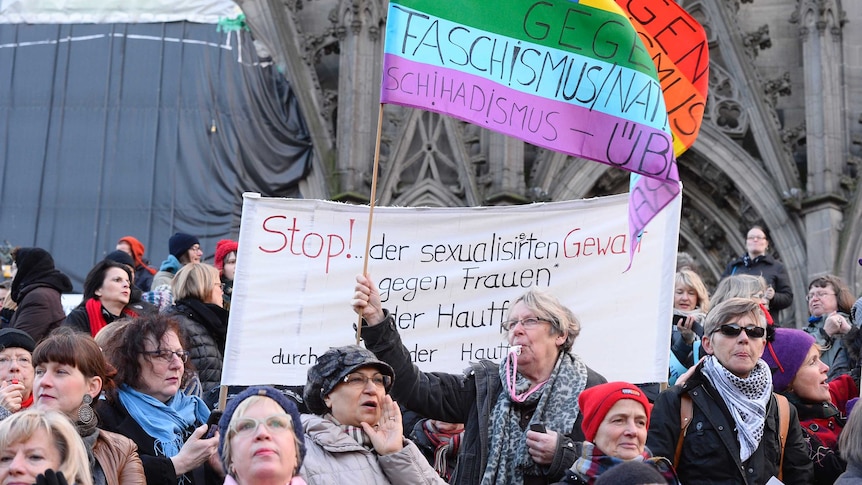 Women hold up signs in protest.