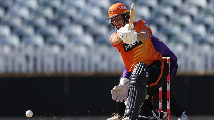 A Perth Scorchers WBBL batter drives the ball on one knee.