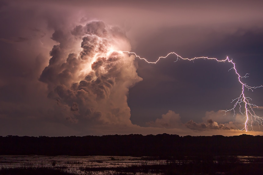 A bolt of lightning travels horizontally from a large storm cloud before touching down well in advance of the storm in Darwin