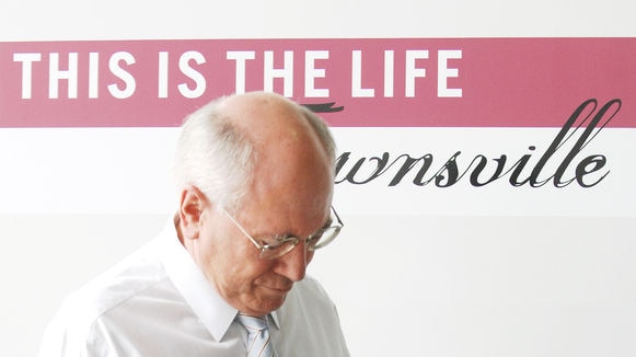 John Howard walks past a truck in Townsville