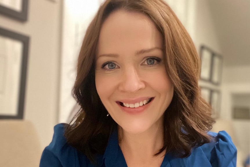 Woman with brown hair smiles at the camera