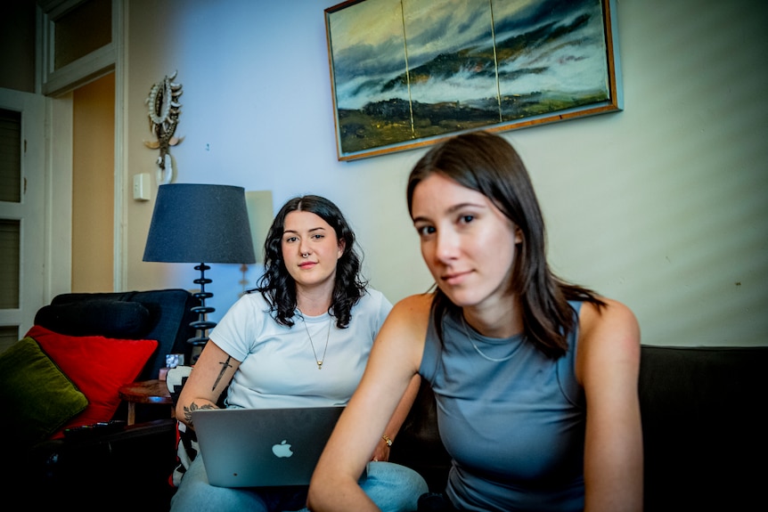 Two women sitting on a couch.