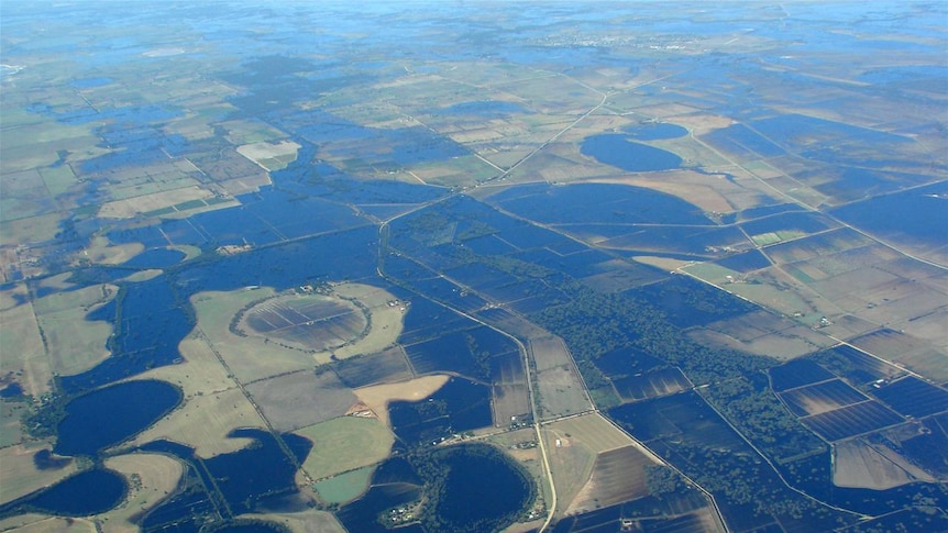 An aerial view of farmland, about half of which are covered in water.