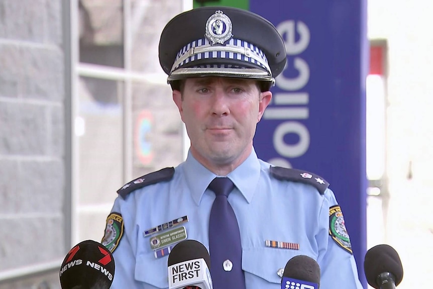 Detective Superintendent Simon Glasser stands in front of microphones in auburn ahead of a press conference