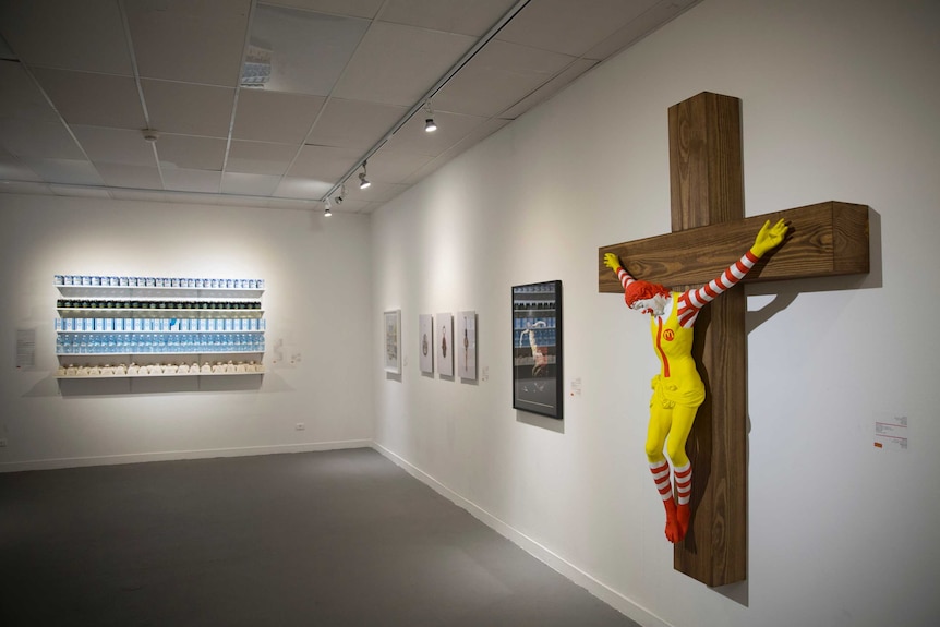 An exhibit showing Ronald McDonald nailed to a cross.