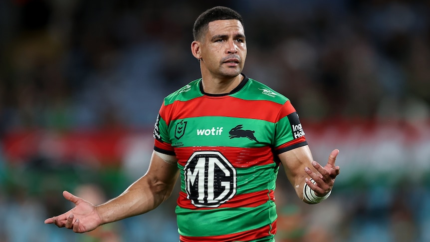 A South Sydney NRL player holds his arms out in question during a game.