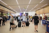 Passengers walk through the arrivals area of an airport