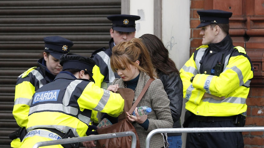 Irish police check a woman's bag at a roadblock in Dublin