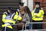 Irish police check a woman's bag at a roadblock in Dublin