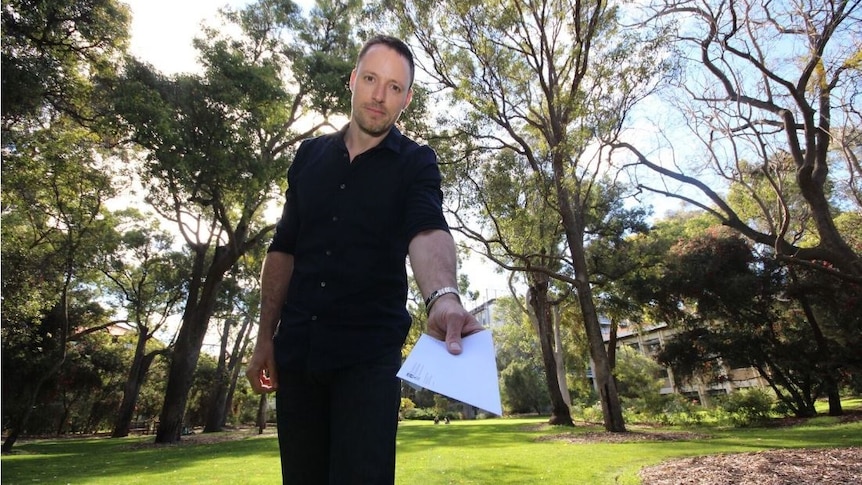 UWA researcher Cyril Grueter holds a letter