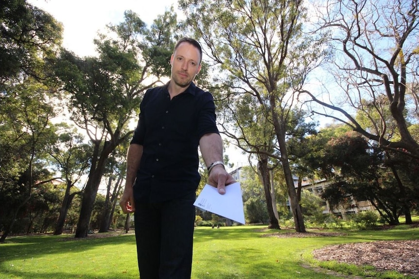 UWA researcher Cyril Grueter holds a letter