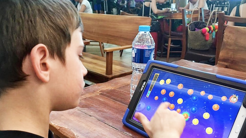 Child playing a game on a screen.
