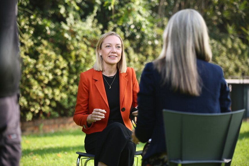 Mia Davies sits down talking to a reporter during an interview in the Fern Garden.