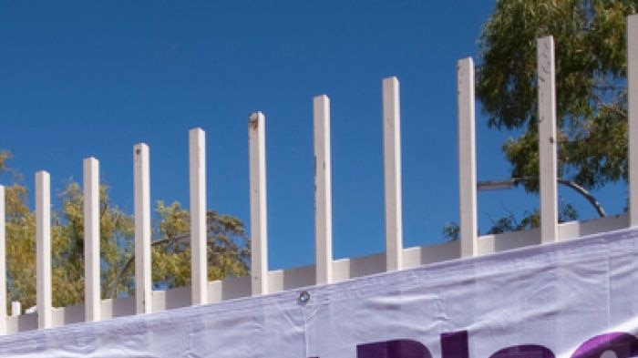 An Australian Electoral Commission banner attached to a fence reads 'Polling Place: Open 8am to 6pm'.