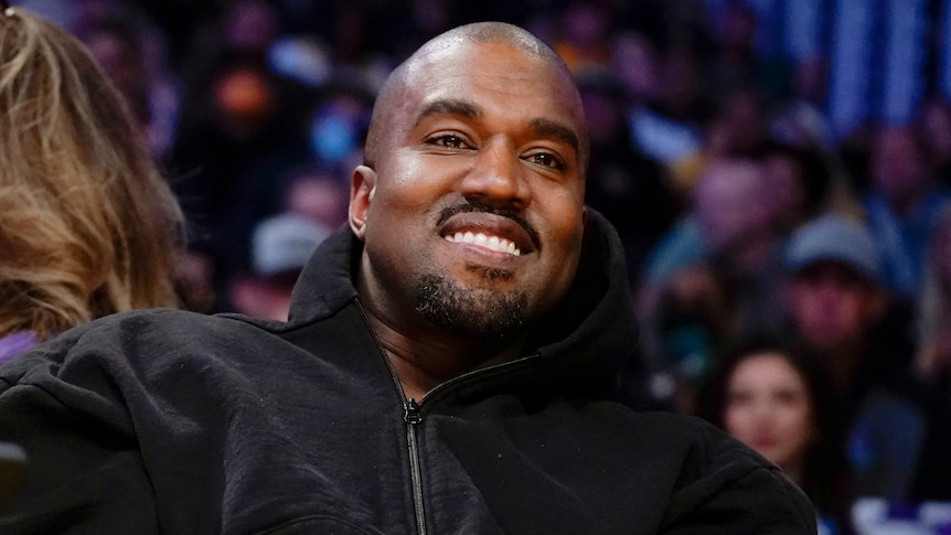 Kanye West smiling and looking into the distance.
