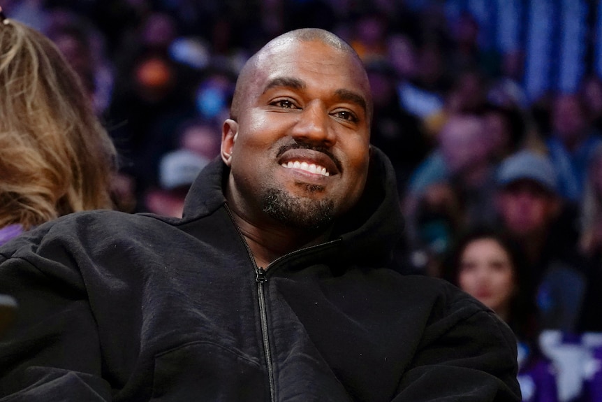 Kanye West smiling and looking into the distance.