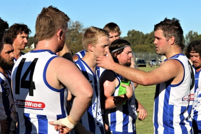 Buchan Football Club players stand and talk together