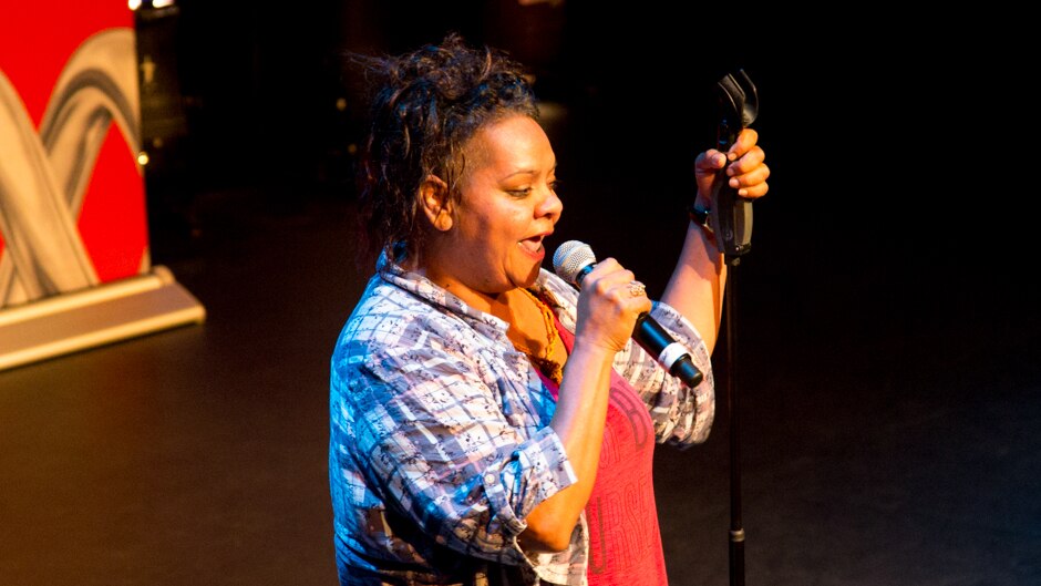 A woman on stage with microphone.