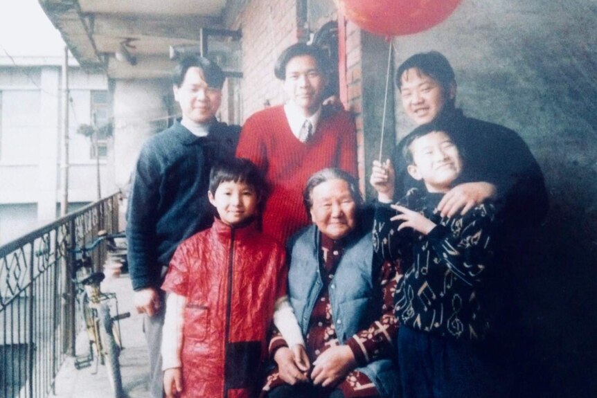 Bang was standing next to his grandmother with the other four cousins standing around.