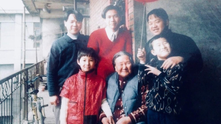 Bang was standing next to his grandmother with the other four cousins standing around.