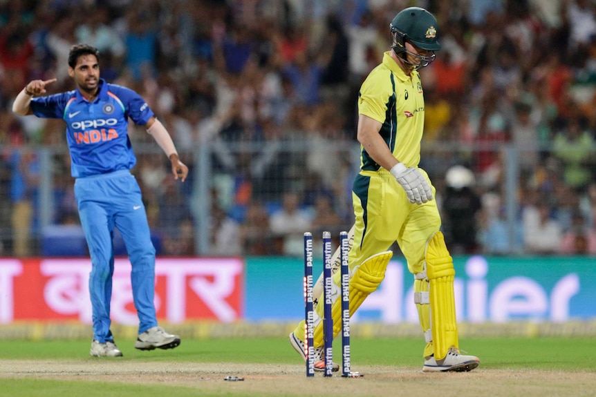 Australian batsman Hilton Cartwright walks off the field with  India's Bhuvneshwar Kumar behind him in a ODI match.