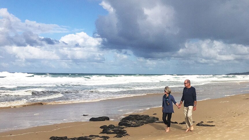 Nola Droop and her husband walk on the beach