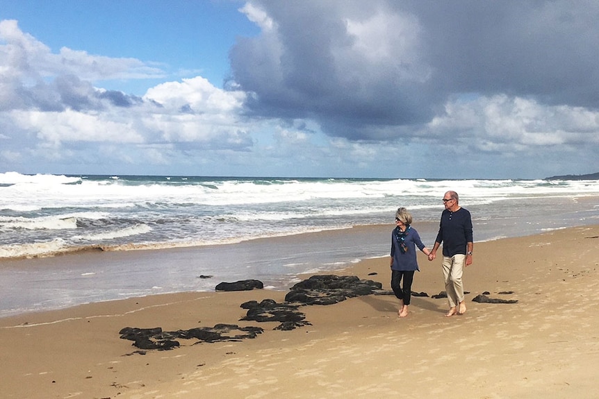 Nola Droop and her husband walk on the beach