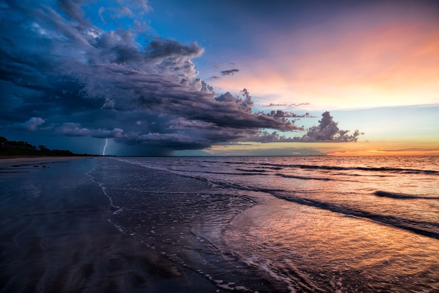 Lightning strikes at the beach at sunset.