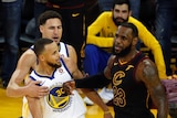 LeBron James pushes Steph Curry with his forearm as Kaly Thompson pulls Curry away.
