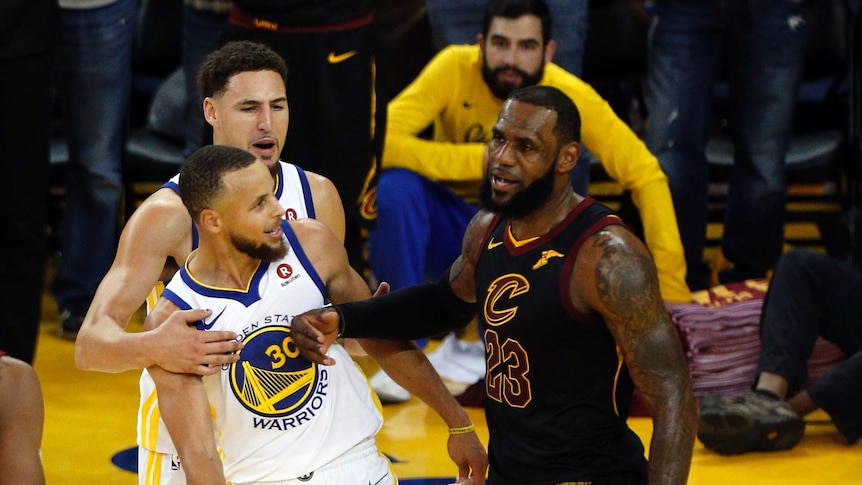 LeBron James pushes Steph Curry with his forearm as Kaly Thompson pulls Curry away.