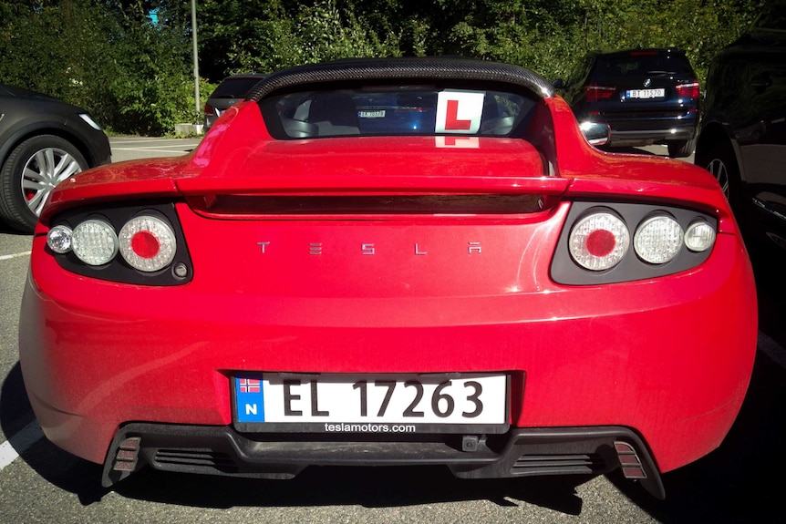 Red Tesla car in carpark