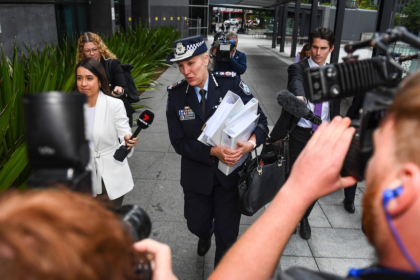 press surround carroll as she leaves court holding a stack of papers