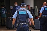 Police stand outside the entrance of Rydges Hotel.