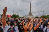 Pro-democracy activists flash three-fingered salute during a demonstration at Victory Monument in Bangkok.