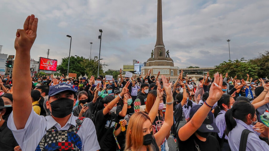 Pro-democracy activists flash three-fingered salute during a demonstration at Victory Monument in Bangkok.