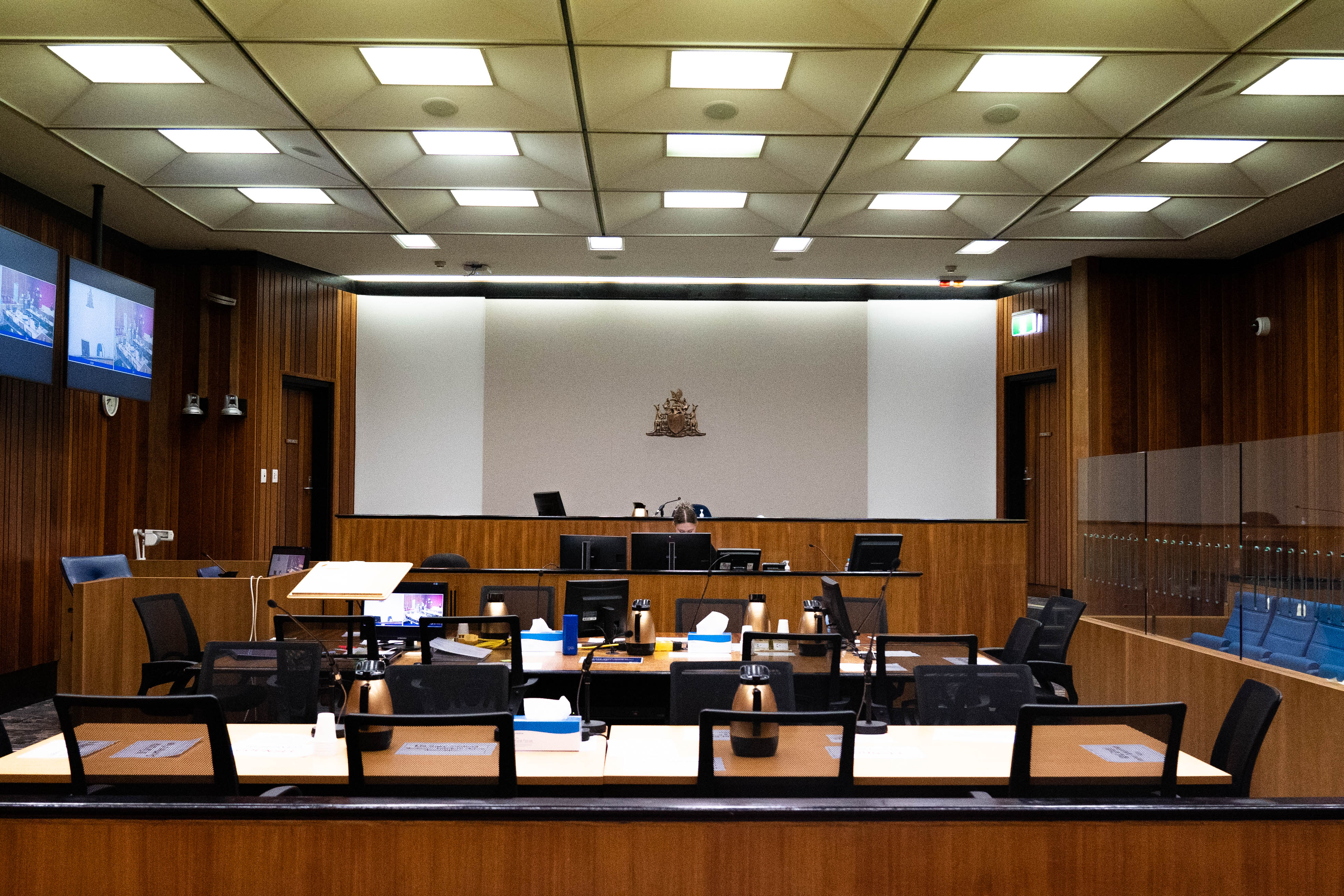 A room with lines of tables and chairs and a bar table at the front. A dock is to the right. 