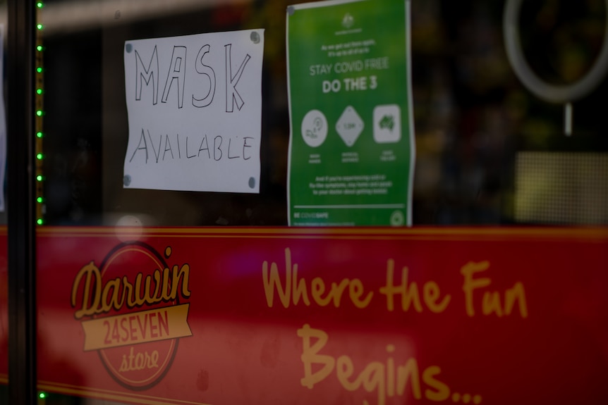 A 'mask available' sign is seen on a shop door in Darwin.