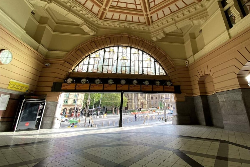 A picture of an empty Flinders Street Station, looking out onto an empty Flinders Street.