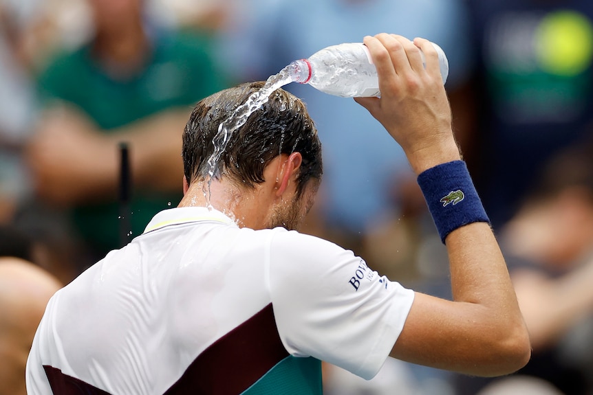 Daniil Medvedev pours water on his head during a match at the US Open.
