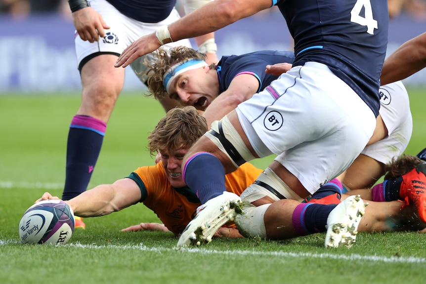 Michael Hooper reached out and stretches to score a try with a ball in one hand