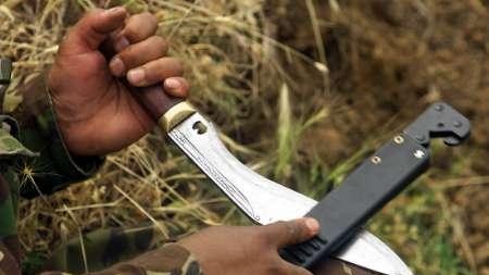 A man holds and sharpens a kukri knife.