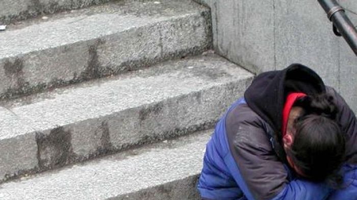 A man sits in a despairing pose