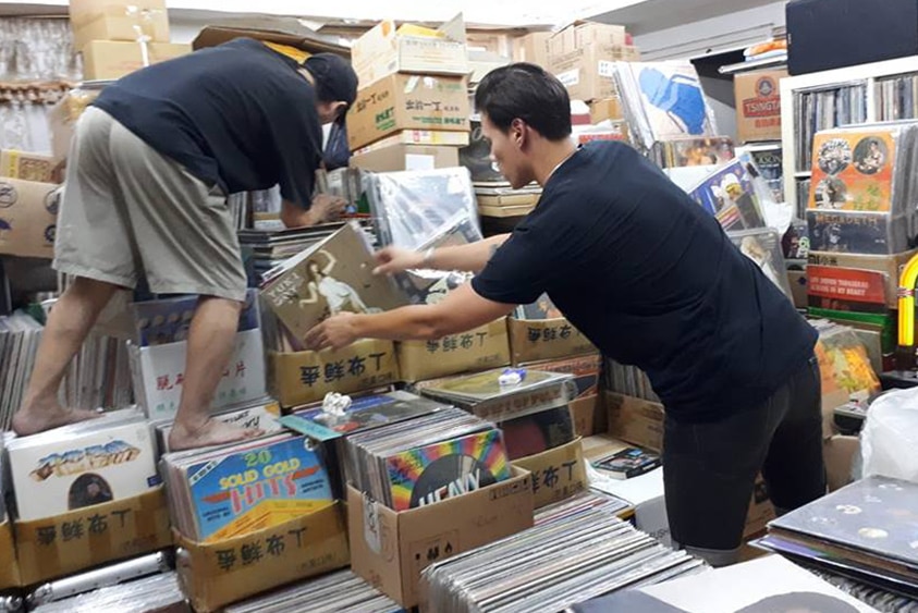 Two men clamour over boxes of records at Vinyl Hero in Hong Kong