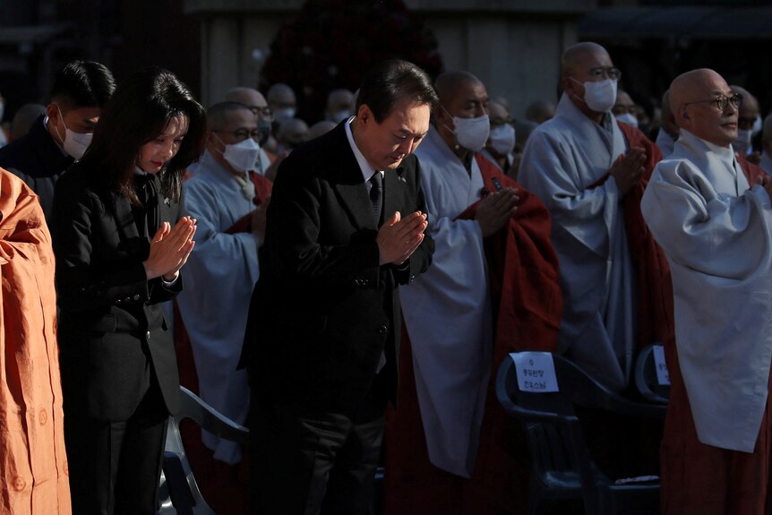 South Korean President Yoon Suk-yeol (centre) praying alongside his wife and monks.