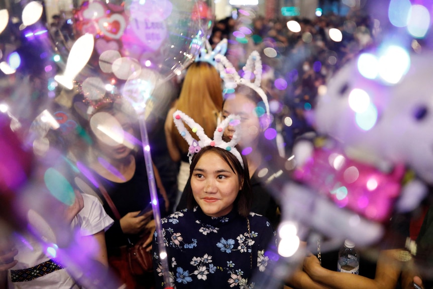 A reveler celebrates New Year's Eve in Kuala Lumpur wearing rabbit ears.