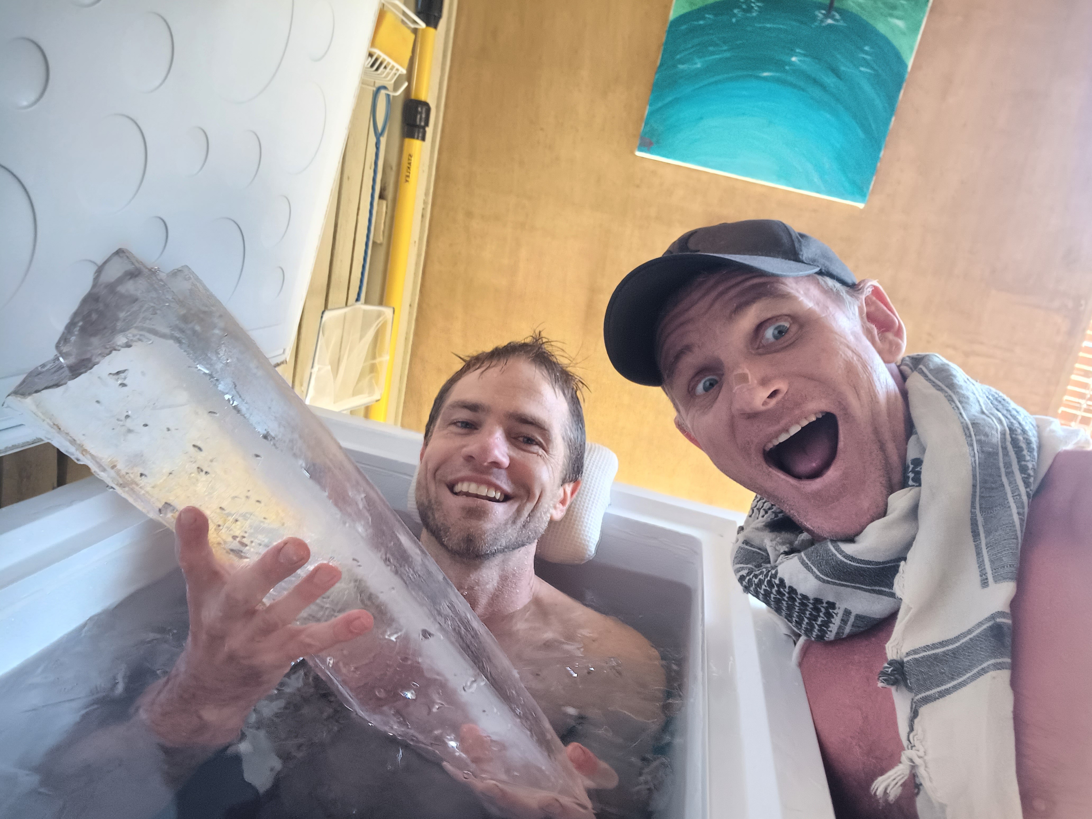 A man in an ice bath next to an excited man